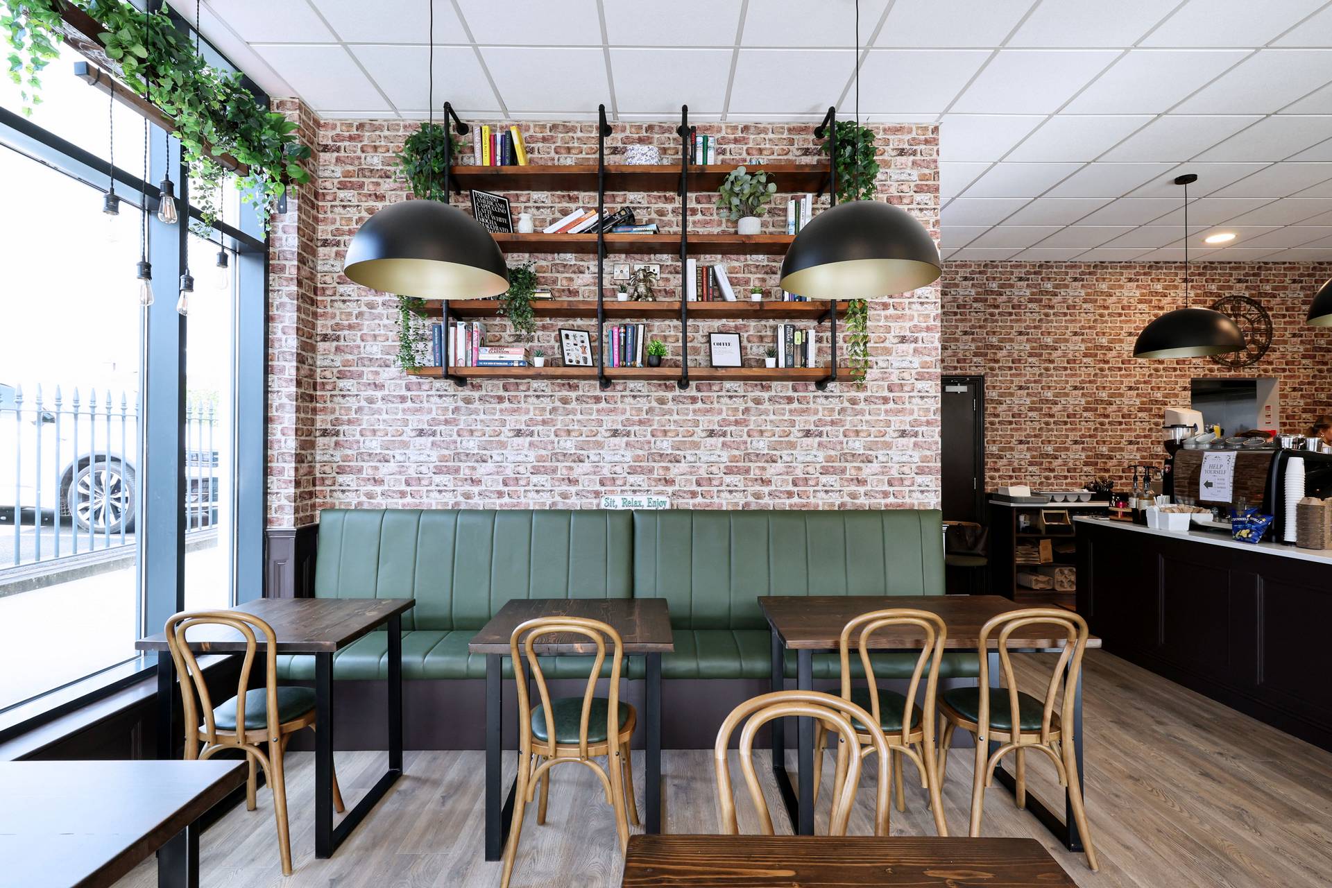 Inside Oak & Ivy Coffee House – green booths and brick walls